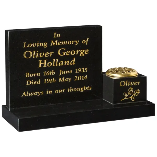 An offset flat top shaped memorial with a rectangular base and a memorial vase sitting to the right of the base.